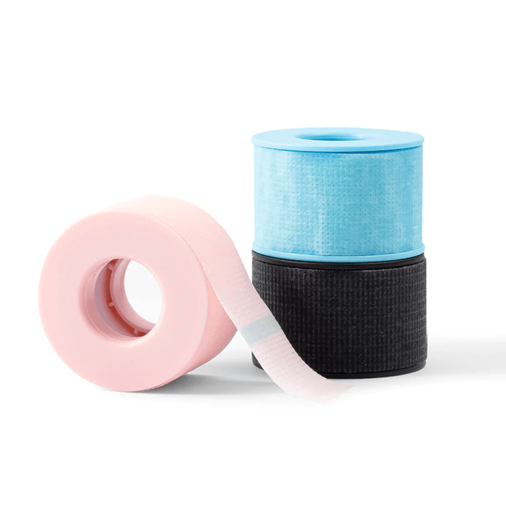 Pink, blue and black silicon gel tape rolls for eyelash extensions on a white background. Low-trauma tape for sensitive skin.