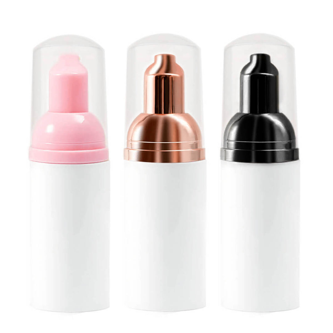 Eyelash Extension Cleanser Foam bottles in pink, copper and black pump heads, white bottles, essential lash care product.