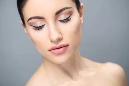 A woman with closed eyes, showcasing long, voluminous eyelashes.