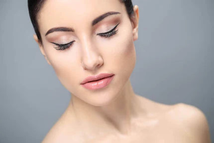 A woman with closed eyes, showcasing long, voluminous eyelashes.