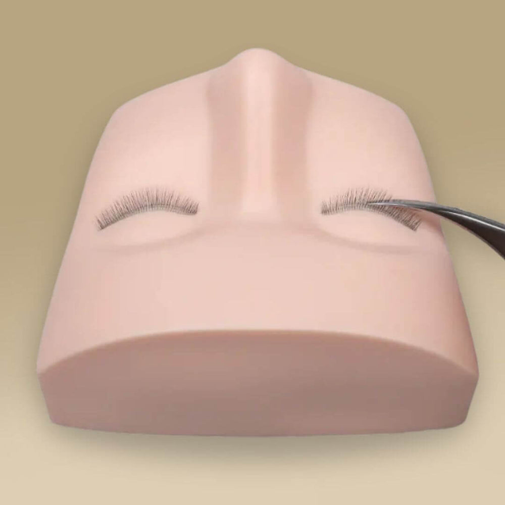 Practicing eyelash extensions on mannequin head with tweezers