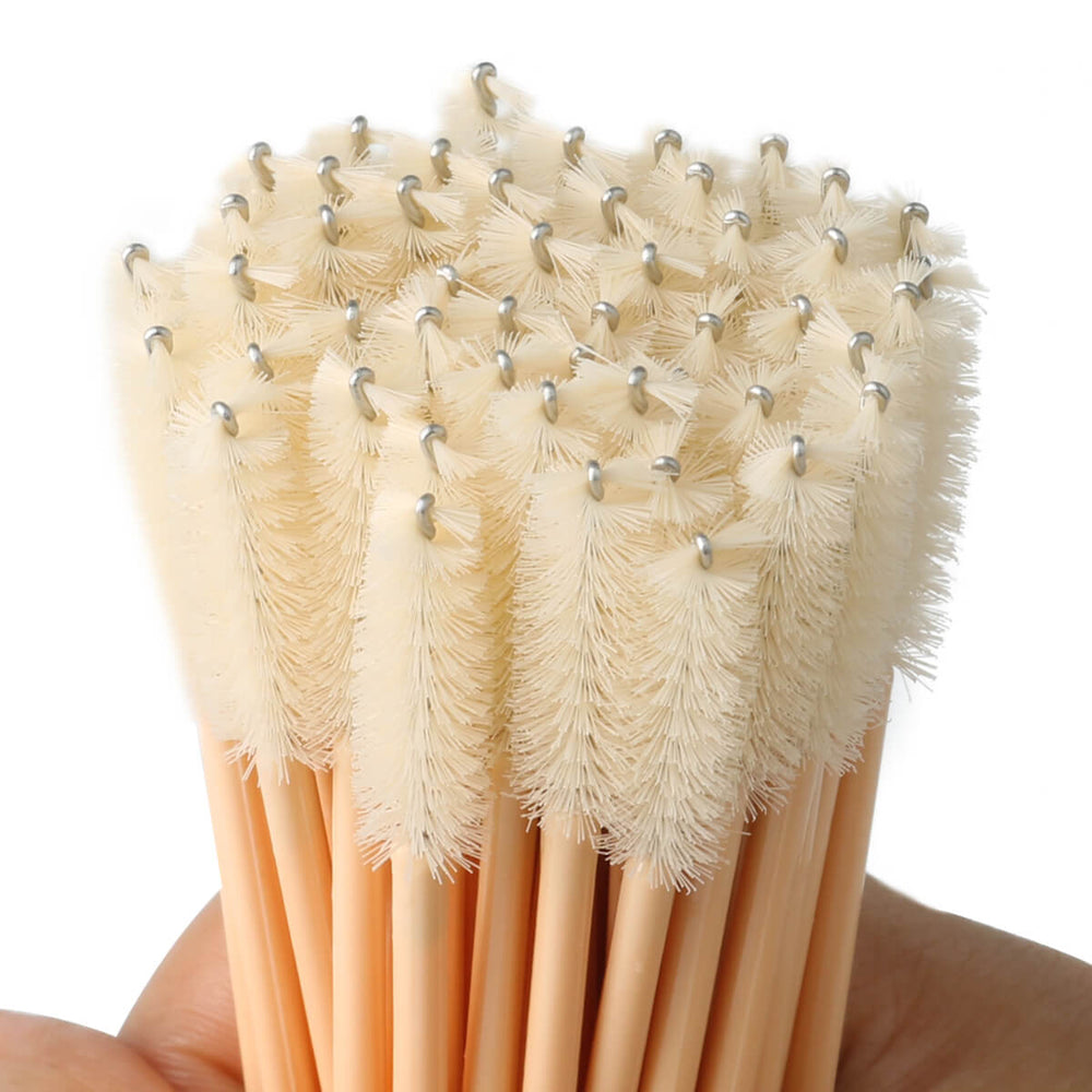Disposable mascara wands with nude wooden handles and fluffy bristles, perfect for brushing classic lash extensions