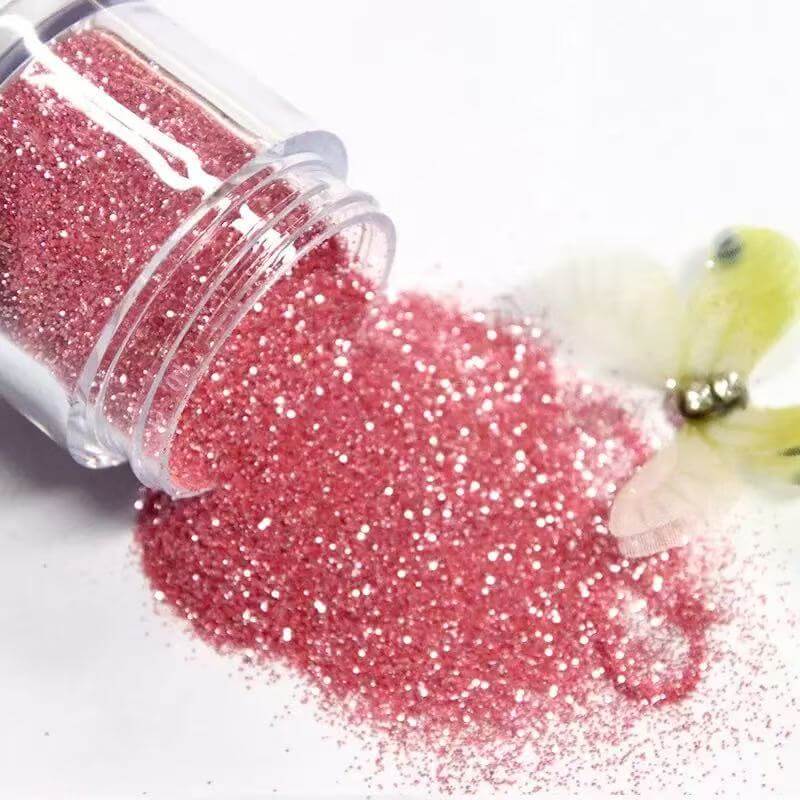Pink lash glitter in clear container for eyelash extensions, adding sparkle