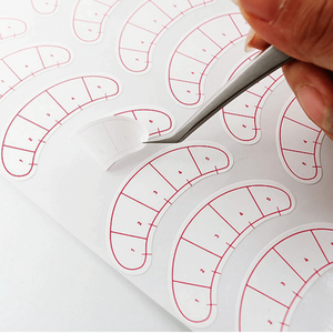 Lash mapping stickers with red numbered lash charts and tweezers on white backing