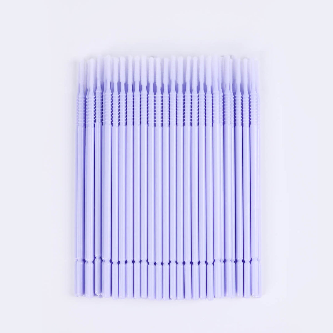 Micro brush swabs for eyelash extensions, clear tube, purple base. Lash primer and remover applicator.