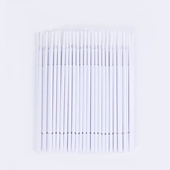 Micro brush swabs for eyelash extensions, applicator with white handle, white tip and clear container.