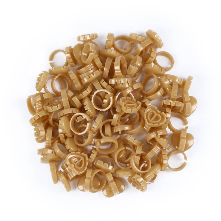 A pile of beige Sweet Heart Glue Cups scattered on a white background.